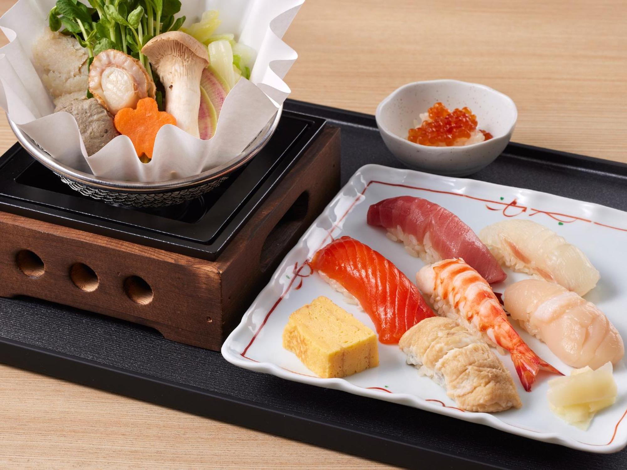 แกรนด์ นิกโกะ โตเกียว เบย์ ไมฮามะ Hotel Urayasu ภายนอก รูปภาพ The photo features a Japanese meal presented on a wooden tray. On the left, there is a small pot with a clear broth containing vegetables, mushrooms, and possibly meat, indicated by green herbs and a piece shaped like a flower. On the right, there is
