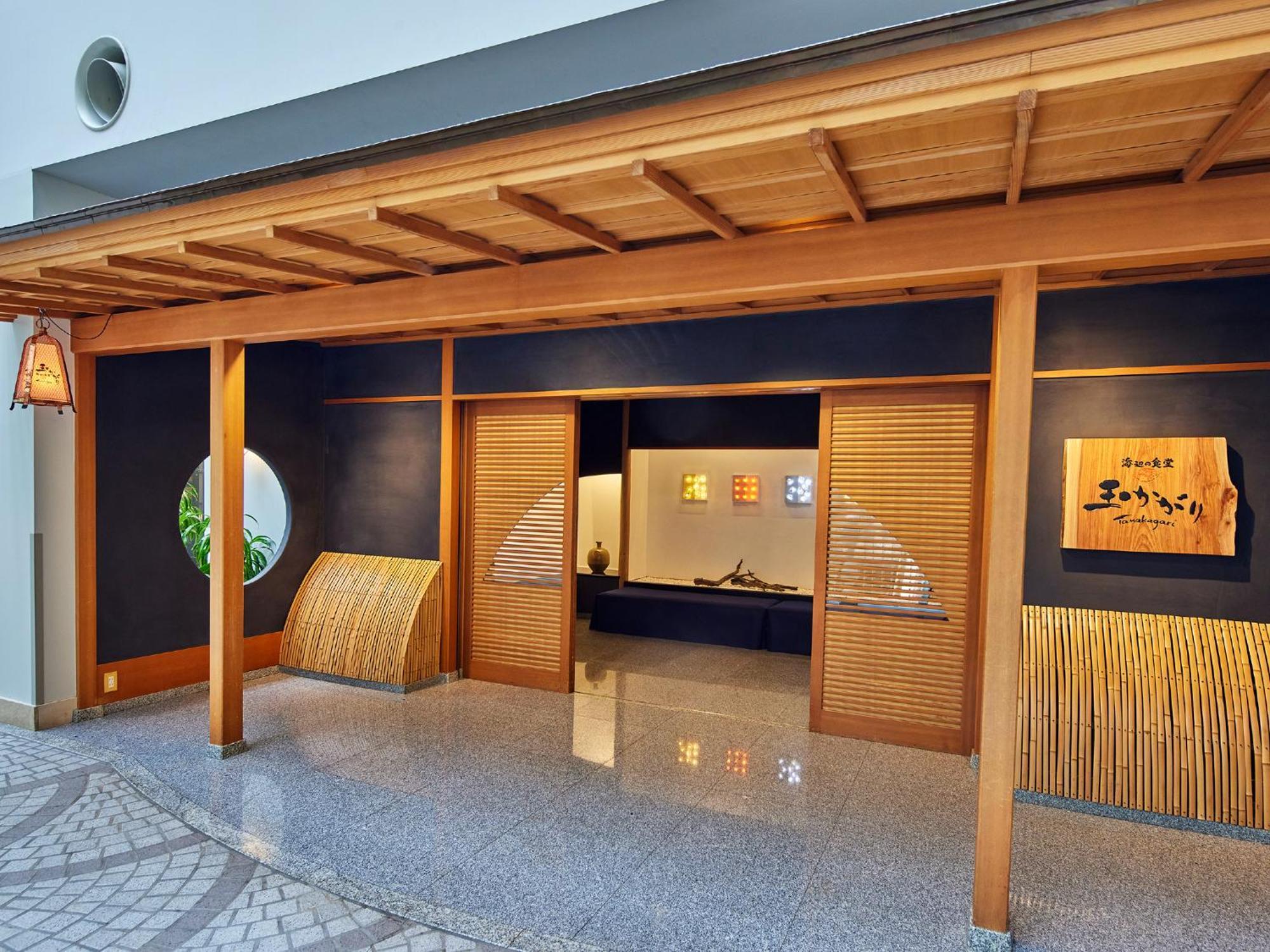 แกรนด์ นิกโกะ โตเกียว เบย์ ไมฮามะ Hotel Urayasu ภายนอก รูปภาพ The photo shows the entrance of a building, designed in a traditional Japanese style. It features a wooden structure with a large overhanging roof and sliding doors. The entrance is flanked by rounded windows, and there's a decorative sign with Japan