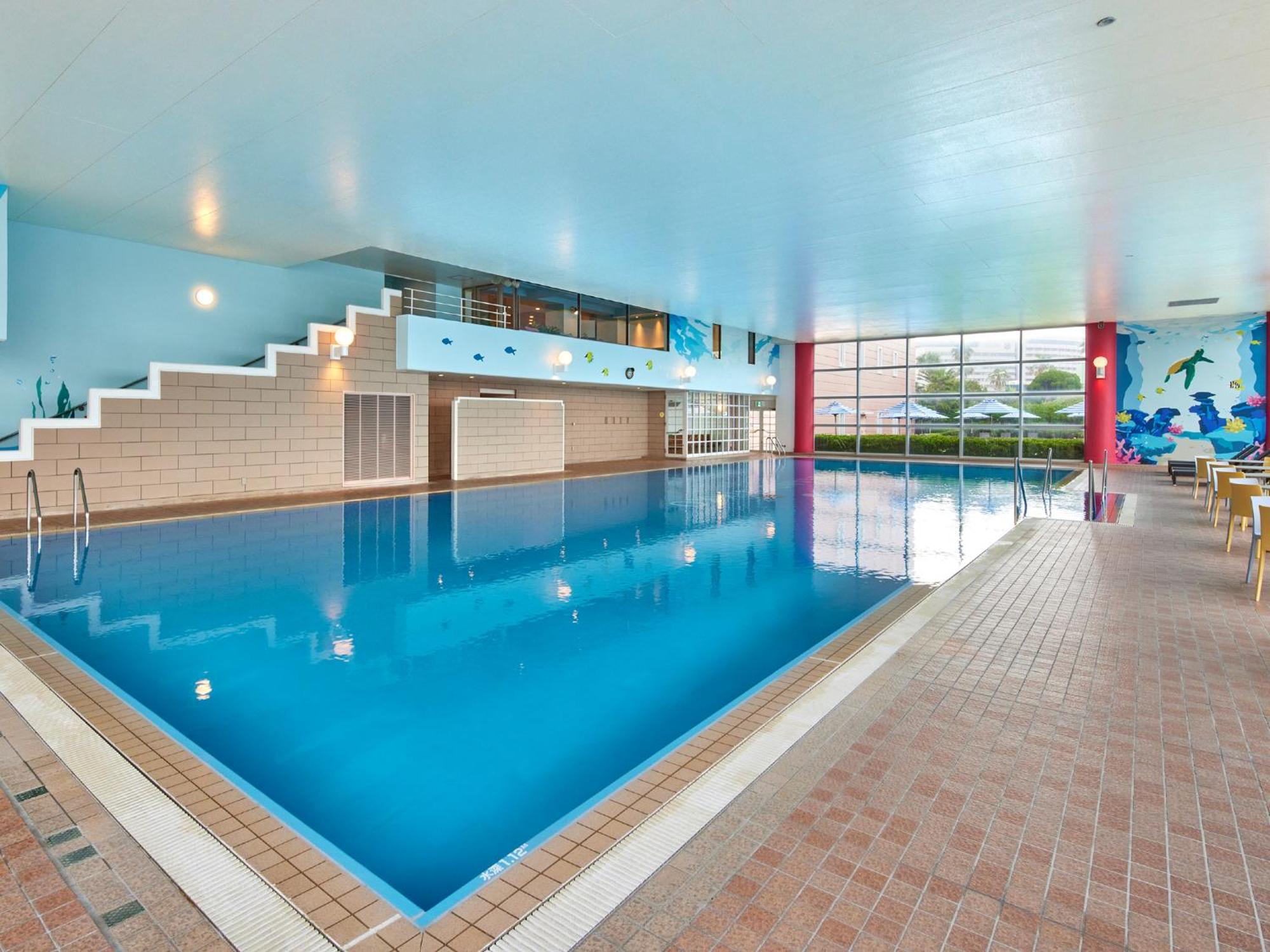 แกรนด์ นิกโกะ โตเกียว เบย์ ไมฮามะ Hotel Urayasu ภายนอก รูปภาพ The photo shows an indoor swimming pool area with a spacious design. The pool has a clear blue water surface and is surrounded by a tiled deck. On one side of the pool, there are steps leading into the water, and there are large windows letting in na